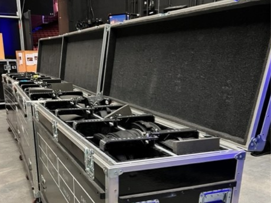A row of black cases with a large amount of equipment in it.