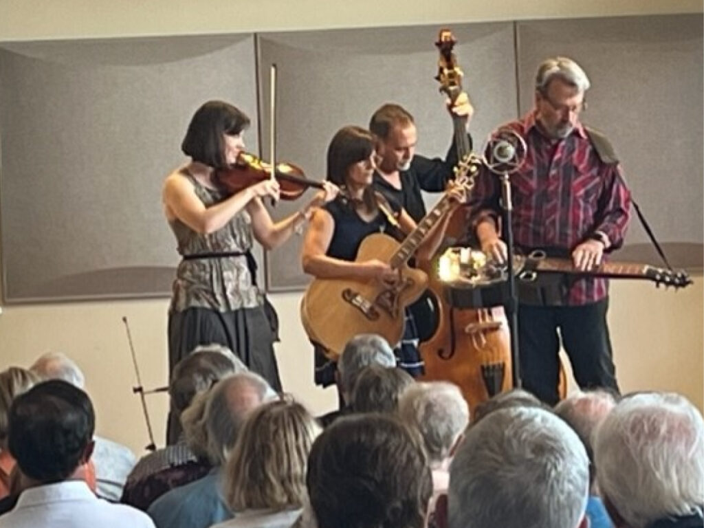 A group of people playing instruments in front of an audience.