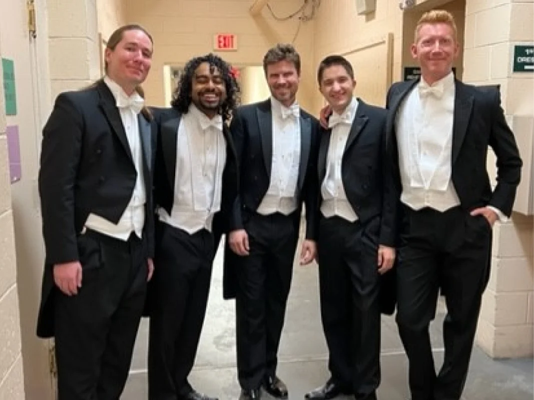 A group of men in tuxedos standing next to each other.