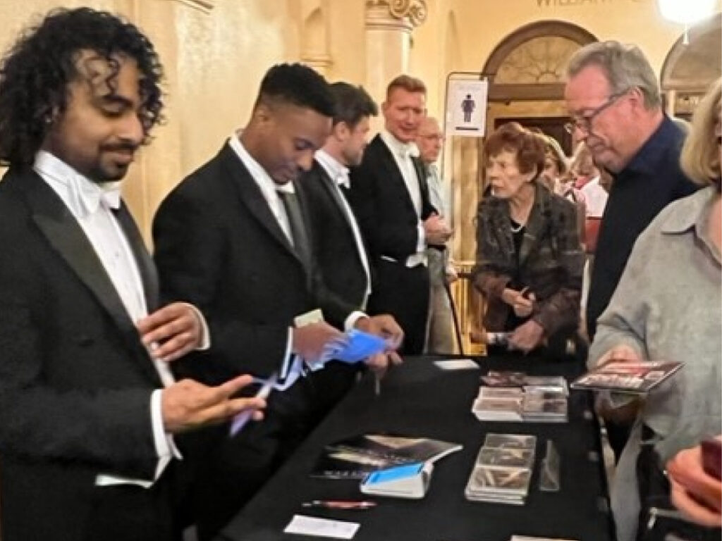 A group of men in suits and ties looking at cards.