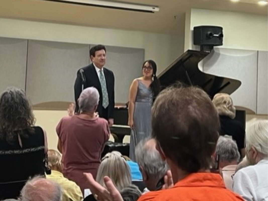 A man and woman standing in front of an audience.