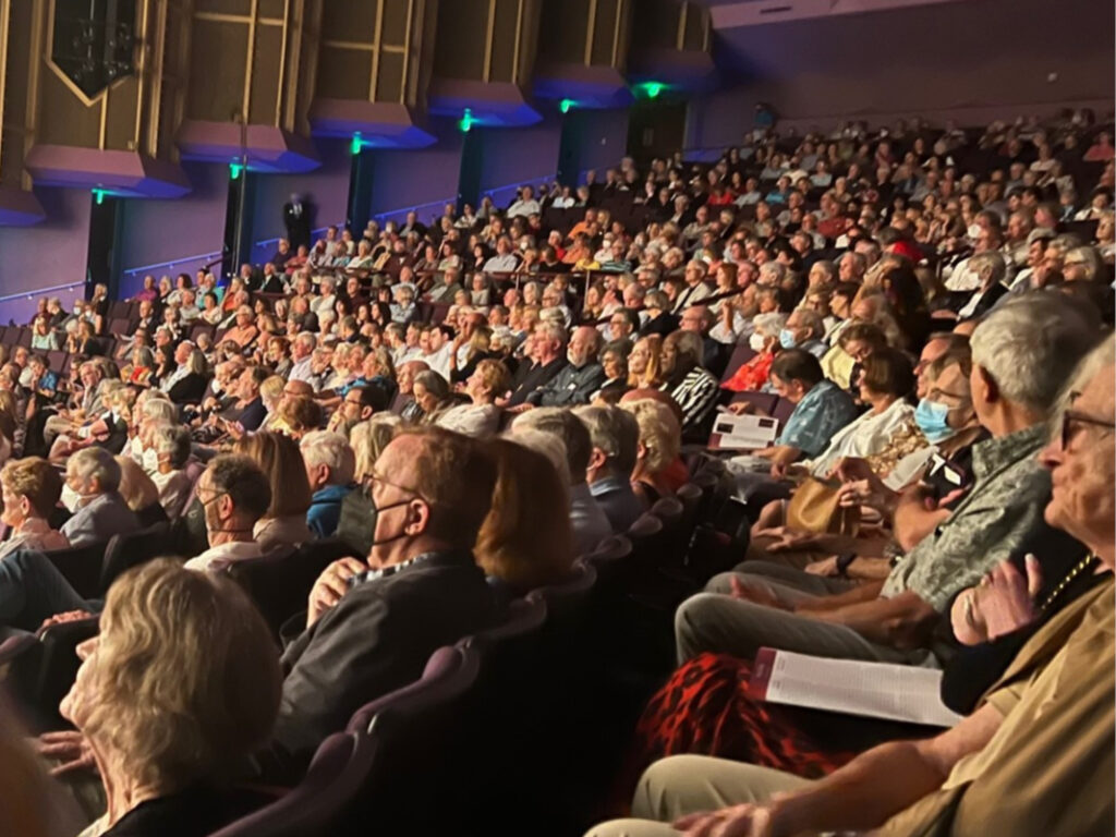 A large crowd of people sitting in rows.